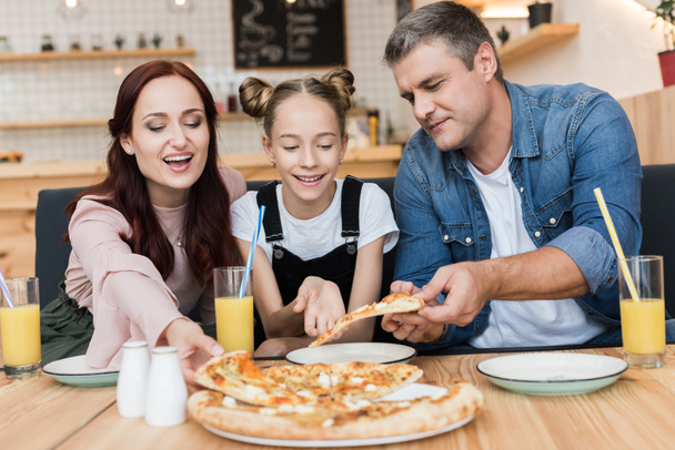 Familia feliz comiendo pizza
 - Foto, Imagen