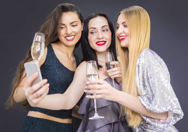Three young pretty woman having fun and making selfie - Foto, imagen