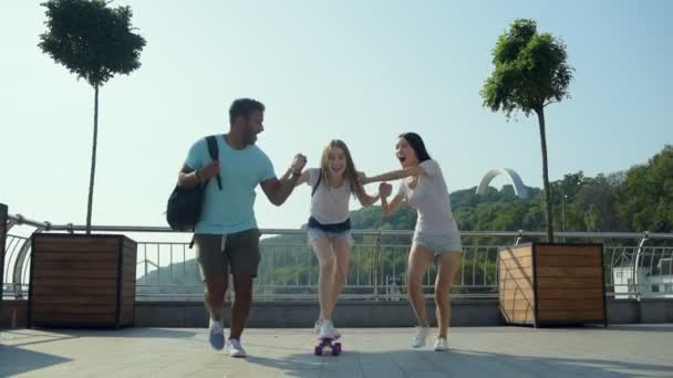 Faithful friends helping a beautiful girl with skateboarding - Footage, Video