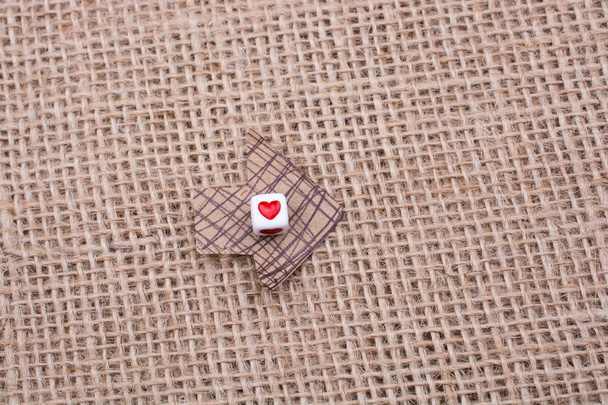 Love cubes on arrow cut out of brown paper on canvas - Photo, Image