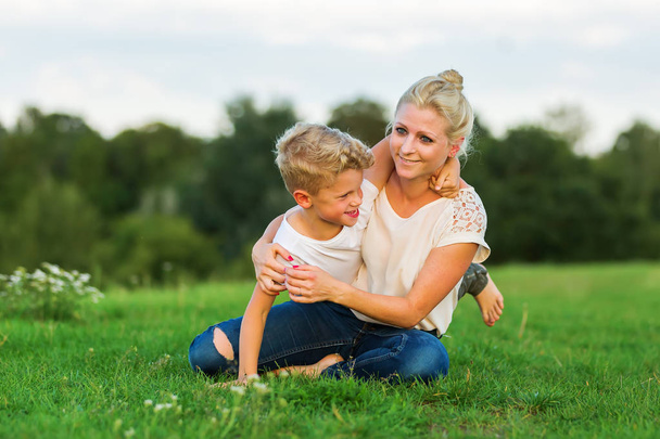 woman romps with her son on the grass - Photo, Image