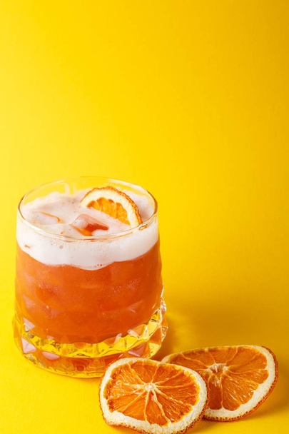 Cóctel naranja con citrón sobre fondo colorido
 - Foto, Imagen