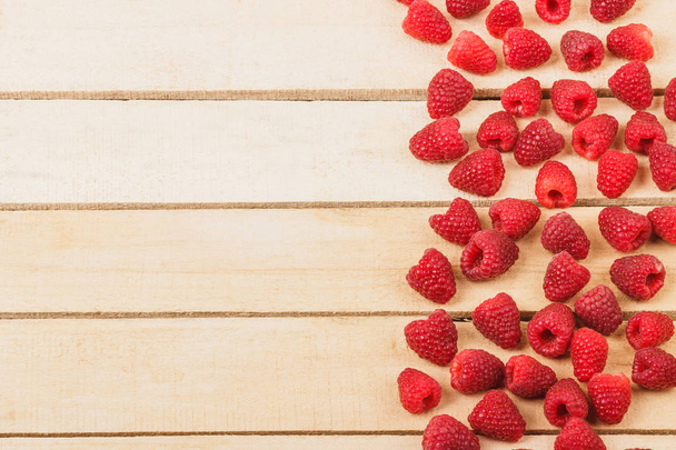 Red raspberries on the light wooden background - Photo, image