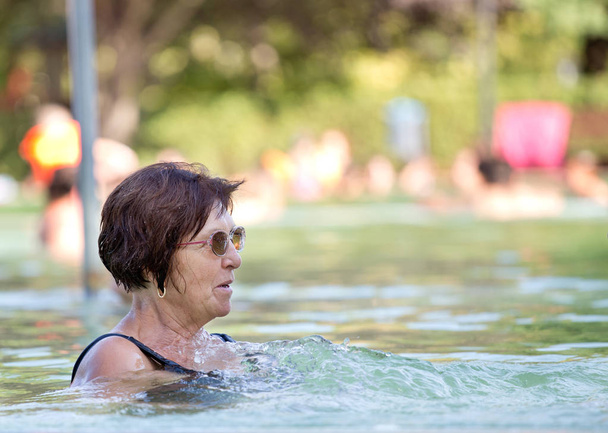 Vecchia donna che riposa in piscina
 - Foto, immagini
