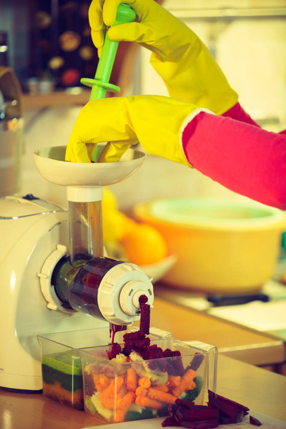 Woman make vegetables juice in juicer machine - Фото, зображення