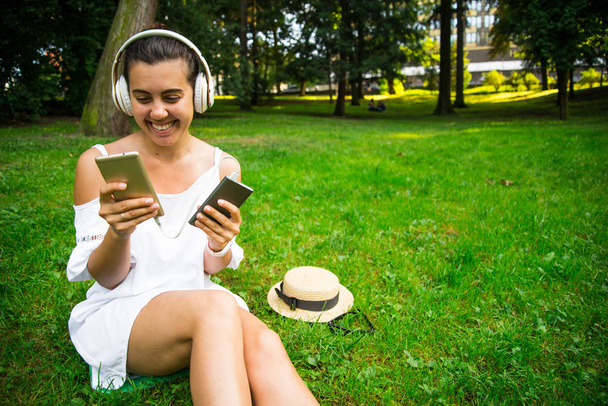 powerbank を使用し続ける幸せの公園で女性が音楽を聴く - 写真・画像