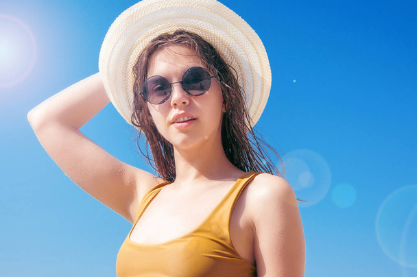 дівчина в сонцезахисних окулярах і капелюсі проти моря
 - Фото, зображення