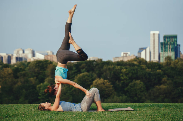 dos mujeres haciendo acro yoga
  - Foto, imagen