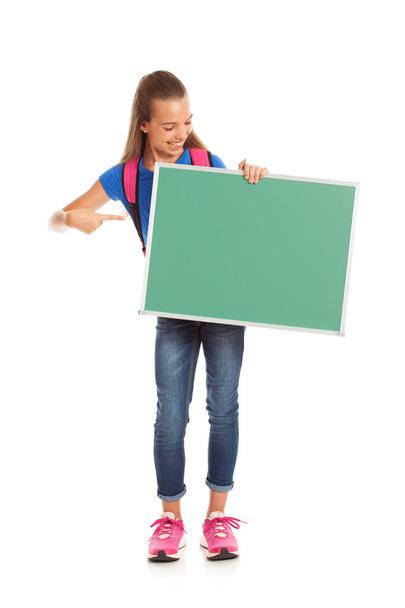 School: Girl Student Looks And Points At Blank Chalkboard - Foto, Imagem