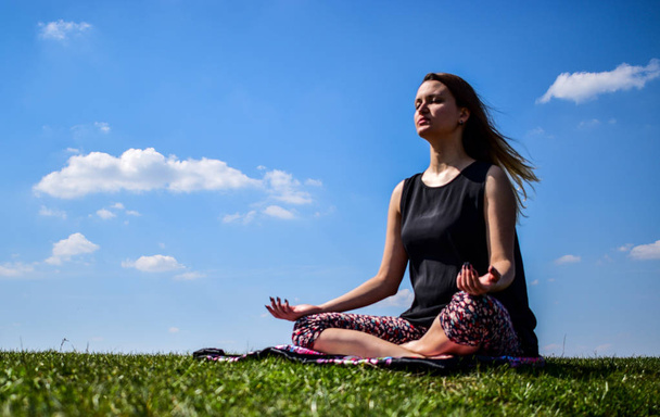 young women meditating in nature in the lotus position - Foto, Bild