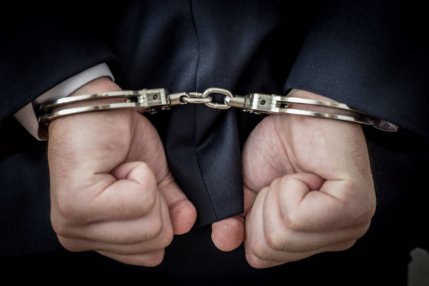 Um homem de negócios preso com algemas nas costas devido à corrupção e
 - Foto, Imagem