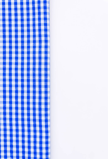 Pano azul, uma toalha de cozinha com um padrão xadrez, em um branco
 - Foto, Imagem