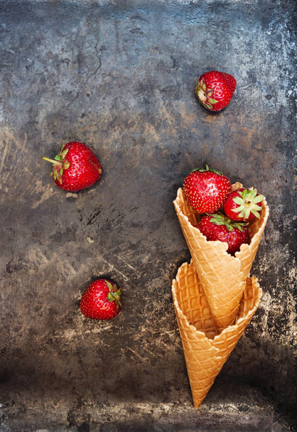 Fresh juicy strawberries in a waffle cone on a dark old backgrou - Foto, Imagem