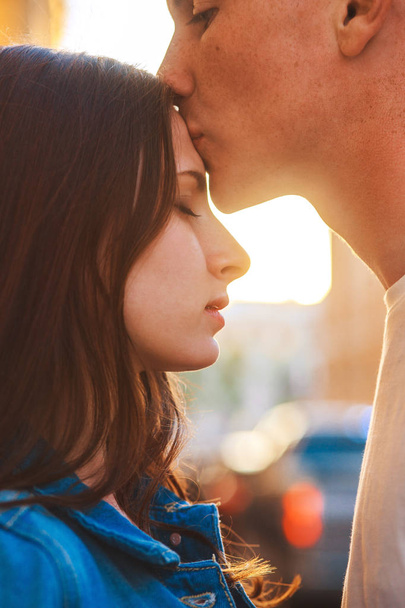 young couple kissing at sunset in city . - Foto, imagen