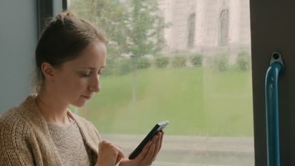 Γυναίκα ταξίδι με το λεωφορείο και χρησιμοποιώντας το smartphone - Πλάνα, βίντεο