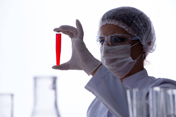 Vrouwelijke wetenschapper onderzoeker voert een experiment uit in een laboratorium - Foto, afbeelding