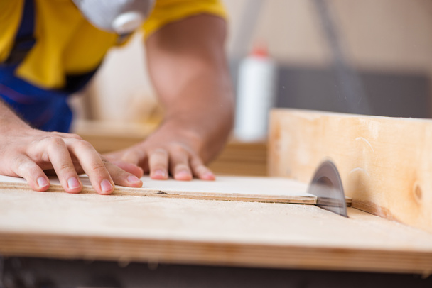 Νέος τεχνίτης ξυλουργός που εργάζεται με δισκοπρίονο - Φωτογραφία, εικόνα