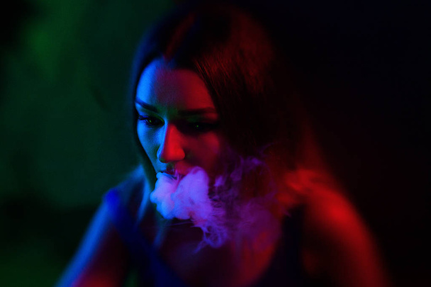 Fashion art portrait of beauty model woman in bright lights with colourful smoke. - 写真・画像
