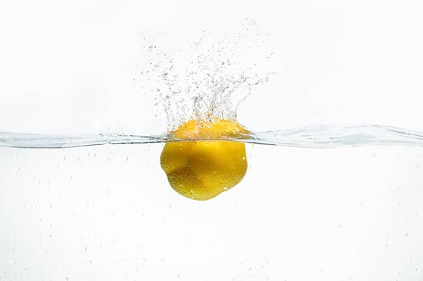 Lemon being dropped into water isolated on white - Фото, изображение