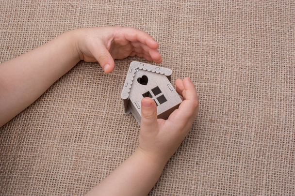 Gyermek kezében egy modell ház egy vászon - Fotó, kép