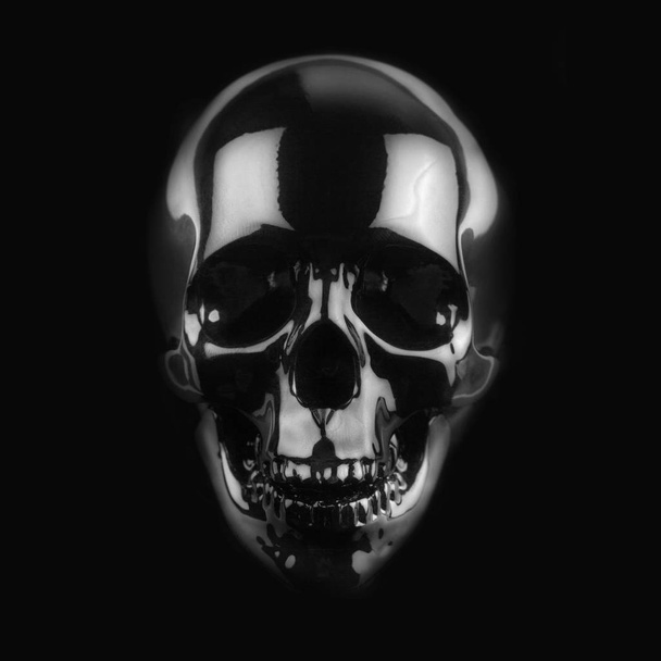 暗い背景に黒い光沢のある頭蓋骨 - 写真・画像