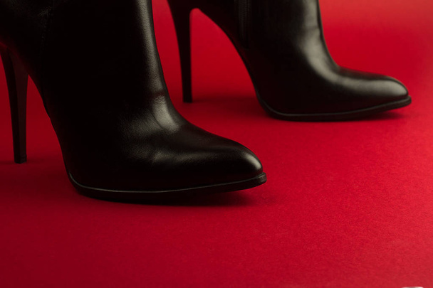 high heel black shoes on red background - Foto, afbeelding