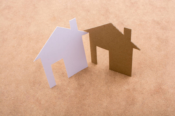 Маленькие бумажные домики на коричневом фоне - Фото, изображение