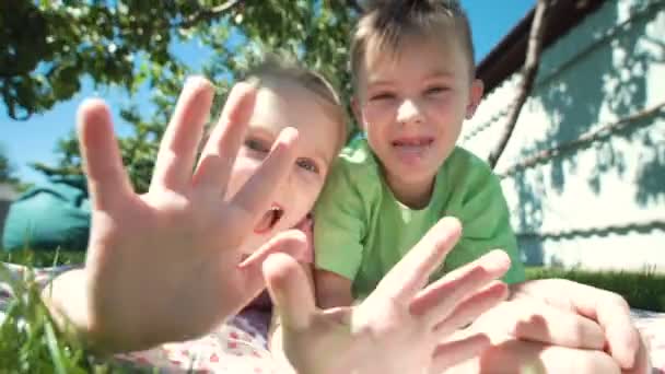 Grimacing lapset poseeraa nurmikolla
 - Materiaali, video