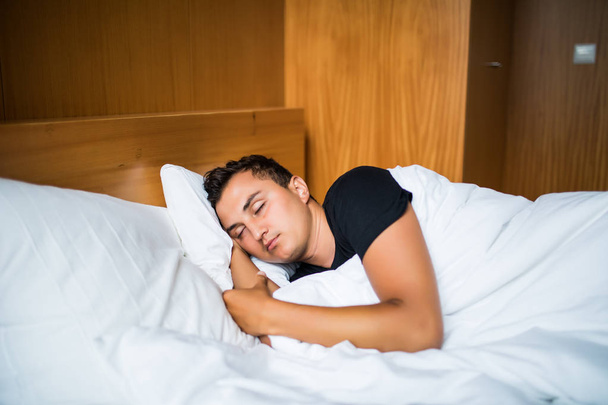 Handsome Man comfortably sleeping in his bed at night - Photo, Image