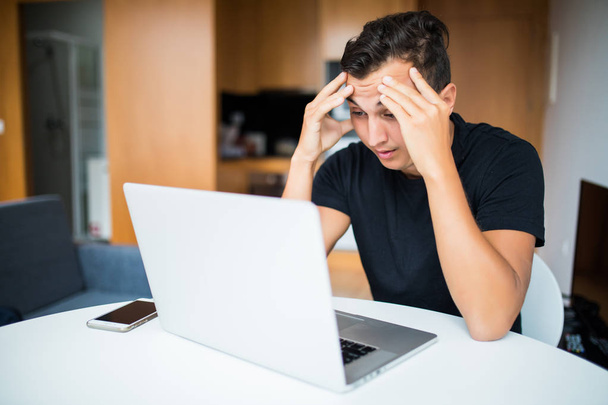 Surullinen itsenäinen yrittäjä työskentelee kotoa kannettavalla tietokoneella
 - Valokuva, kuva