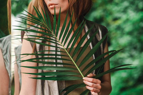 Lips of a girl with a fern branch - Photo, Image