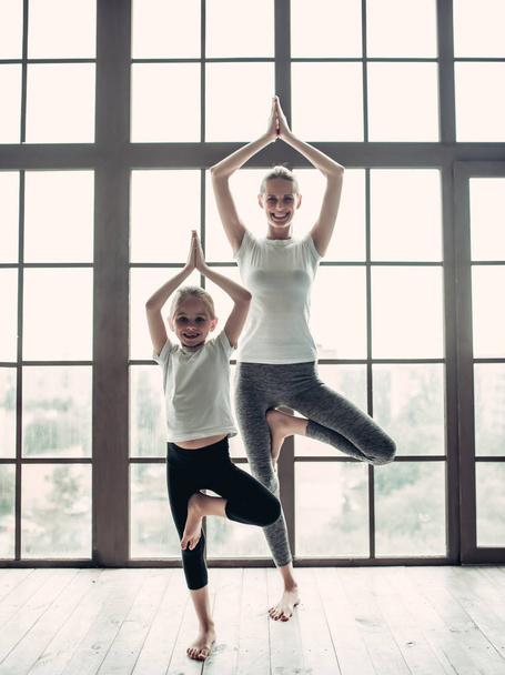 Mom with daughter working out at home - Foto, afbeelding