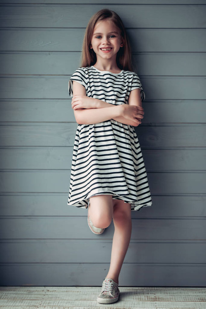 Cute little girl on grey background - Fotó, kép