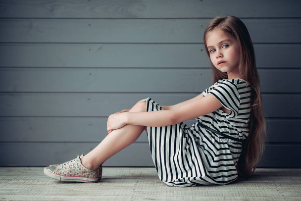 Cute little girl on grey background - Фото, зображення