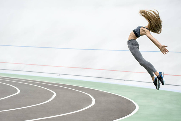 Sportive girl jumping outdoors - Fotoğraf, Görsel