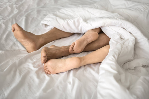 Legs of lovers under blanket - Foto, afbeelding