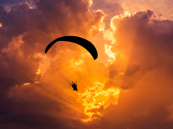 silhueta paramotor voando no pôr do sol
 - Foto, Imagem