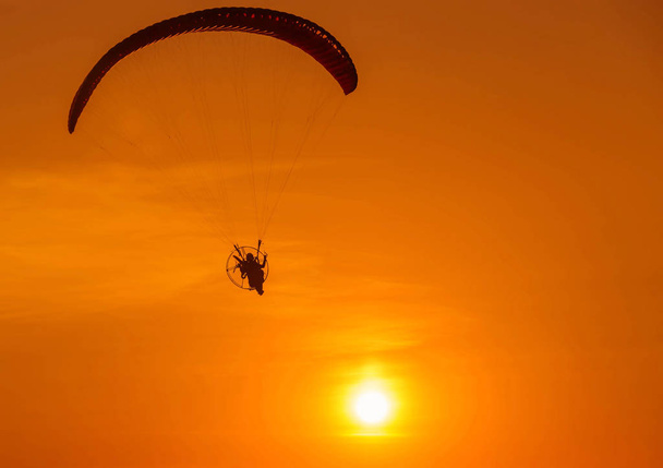 silhouette paramotor flying on sunset - Фото, изображение