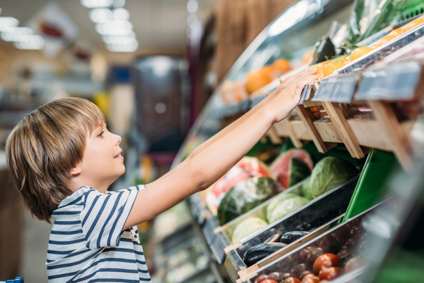 boy choosing food in grocery shop - Zdjęcie, obraz