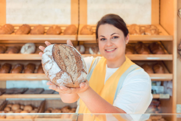 Saleslady presenting bread - Photo, Image