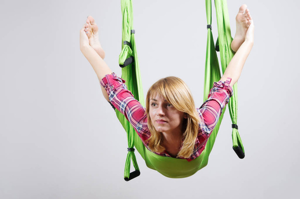 The girl performs exercises in a hammock for yoga - Φωτογραφία, εικόνα