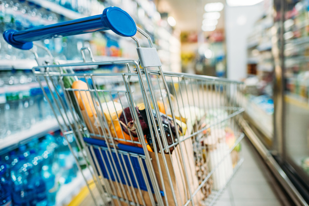 shopping cart with purchases in supermarket - 写真・画像