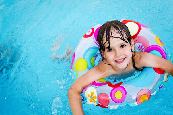 Little girl in swimming pool with float ring - Foto, Imagen