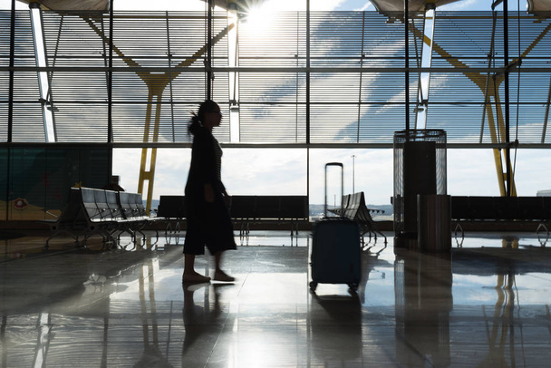Женщина идет за своим багажом
 - Фото, изображение
