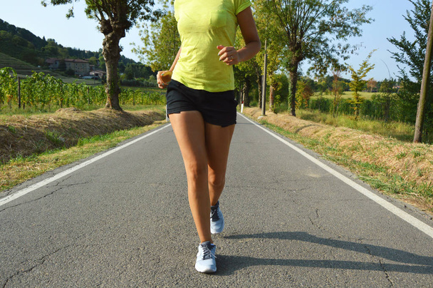 Fitness nainen käynnissä asfalttitiellä
 - Valokuva, kuva