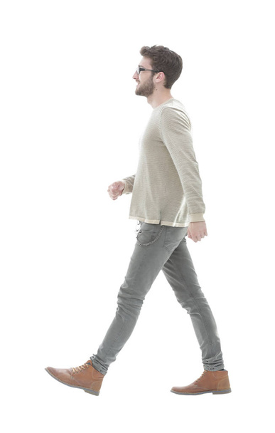 Side view.Young smiling man walking forward - 写真・画像