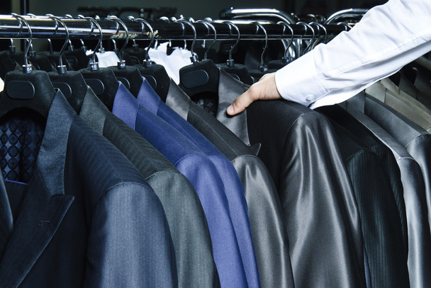 Man choosing business jacket from the raw in the shop - Photo, Image