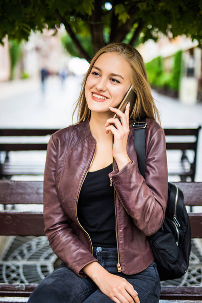 smiling young woman or teenage girl calling on smartphone on city street - Фото, зображення