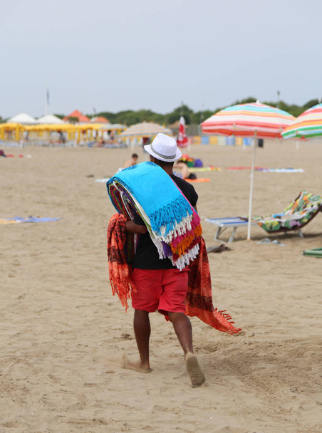 Καταχρηστική περιπατητής περπάτημα στην παραλία πώληση βαμβακερά υφάσματα - Φωτογραφία, εικόνα