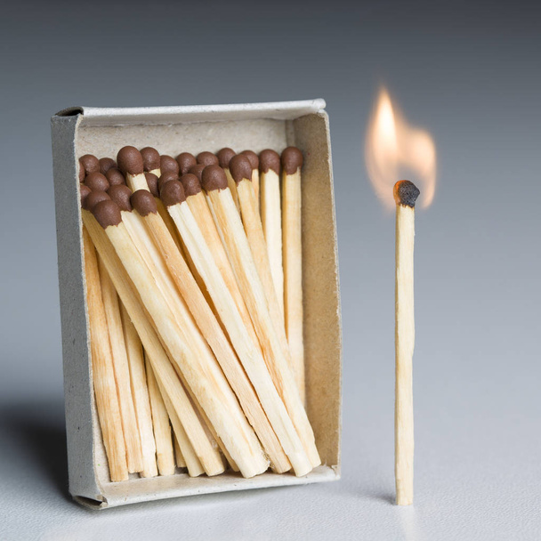 Caja de fósforos y un fósforo en fuego, llama ardiente de fósforos
 - Foto, imagen
